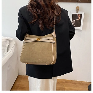 Close-up of suede texture bucket bag with metal turn-lock and vintage bow detail
