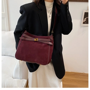 Detail of burgundy faux suede bucket bag with gold square twist lock and smooth leather trim
