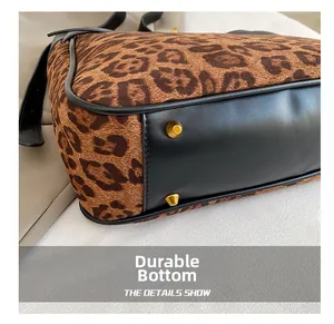 Detailed close-up of leopard print bag bottom with black leather and protective gold studs