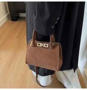 Détail du sac à main vintage marron mat avec fermoir doré et texture aspect suède