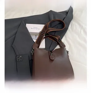 Detailed macro of brown lychee grain leather bucket bag with silver metal buckle