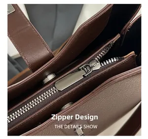 Detail of metal zipper closure and lychee grain leather texture on bucket bag