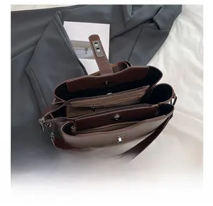 Detail shot of multi-compartment interior and metal zipper in dark brown bucket bag