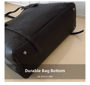 Dettaglio della base della borsa in pelle nera con quattro piedini metallici protettivi