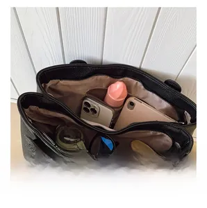 Vista dall'alto della borsa tote in pelle nera con scomparti spaziosi e tasche interne