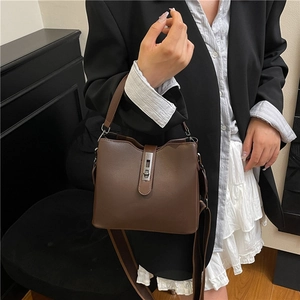 Brown leather bucket bag with silver buckle and wide strap for crossbody carry