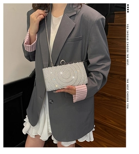 Dettaglio borsa da sera argento con perle concentriche e chiusura ad anello con strass