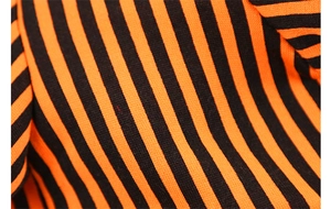Macro view of the thick orange and black ribbed knit fabric detail for pet costumes