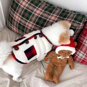 Detail of white plush pet vest with Christmas plaid pockets and a cute teddy bear accessory
