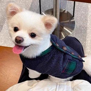 Close-up of blue fleece pet vest with green plaid trim and side buttons for dogs