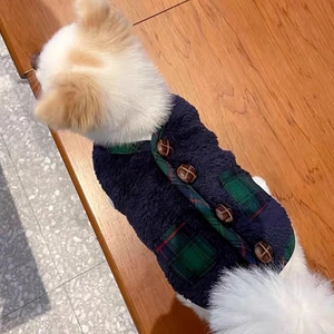 Detail of navy blue plush dog vest with green plaid trim and brown buttons