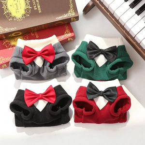 Detail of plush pet suits with white collars and bow ties on vintage background