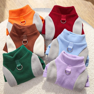 Detail of fleece pet vests in six colors with metal D-rings on soft white plush rug