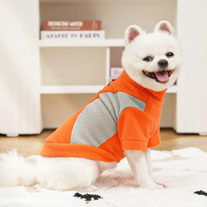 Detail of warm orange fleece pet vest with metal D-ring leash attachment for dogs
