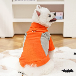 Close-up of bright orange fleece dog vest showing metal D-ring for leash attachment