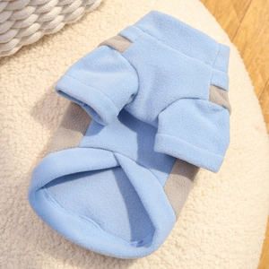 Detail of light blue and grey fleece pet shirt with soft warm texture on white plush mat