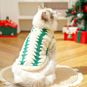 Dettaglio del gilet natalizio per animali in peluche verde e bianco con motivi festivi