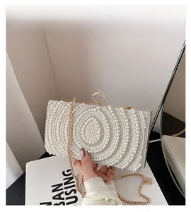 Dettaglio di borsa da sera con perle a goccia e chiusura ad anello con cristalli