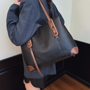 Grande borsa tote in pelle nera martellata con manici marroni e borchie in metallo