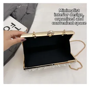 Dettaglio dell'interno semplice e delle perle decorative su una borsa a mano da sera oro