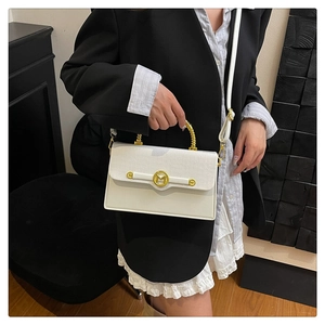 Detail of white PU box bag featuring crocodile texture and golden spiral handle