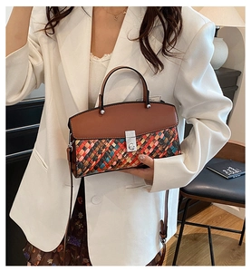 Detail of colorful woven checkerboard pattern and silver twist lock on leather handbag
