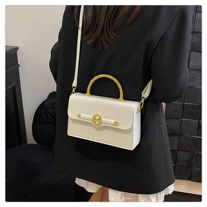 Detail of white PU leather box bag with crocodile texture and gold woven handle on model