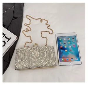 Dettaglio macro della borsa clutch rettangolare con perle e telaio in metallo dorato