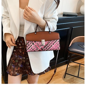 Close-up of geometric woven handbag with leather flap and metallic twist-lock closure