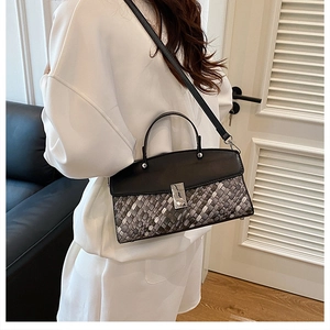Detailed shot of woven texture contrast and metal clasp on the crossbody handbag