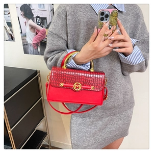 Close-up of red PU leather bag with crocodile texture, gold handle and M-logo buckle