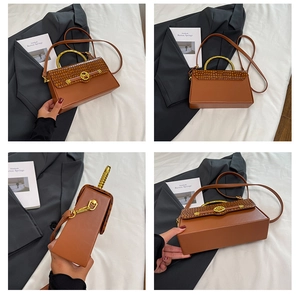 Detail view of brown faux leather box bag with crocodile texture and metal ring handle