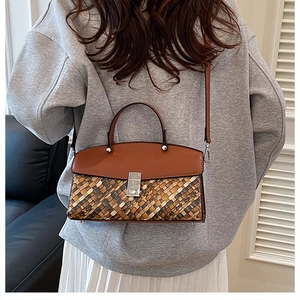 Detailed view of brown woven texture and smooth leather finish on a crossbody bag
