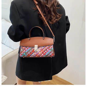 Detail of bohemian colorful woven leather handbag with silver metallic buckle on black suit