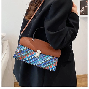 Macro detail of multi-color woven handbag with silver twist lock and smooth leather cover