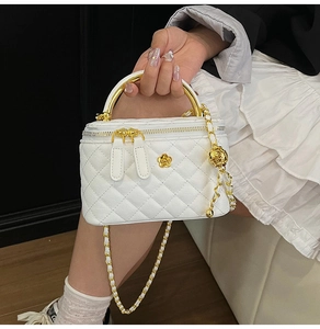 Détail du mini sac vanité blanc à losanges avec chaîne rose dorée et logo fleur