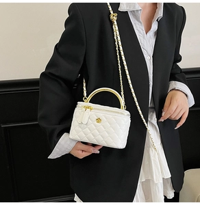 Détail du mini sac blanc matelassé avec poignée ronde dorée et ornement floral chic