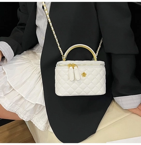 Détail du sac boîte en cuir matelassé blanc avec logo camélia doré et chaîne