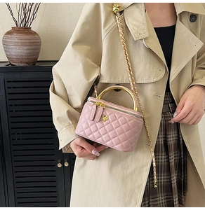 Gros plan détaillé du petit sac rose matelassé avec poignée dorée et bandoulière
