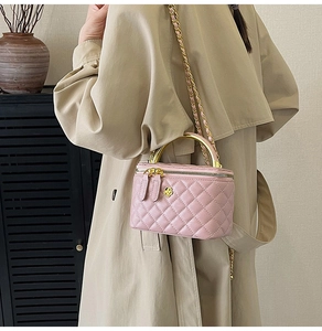 Détail du sac boîte rose matelassé avec fermoir fleur dorée porté par mannequin