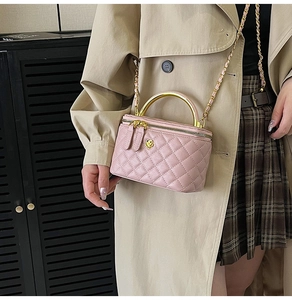 Gros plan du sac boîte rose matelassé avec fleur dorée et bandoulière chaîne