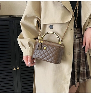 Sac boîte matelassé chic marron foncé porté avec un trench-coat élégant