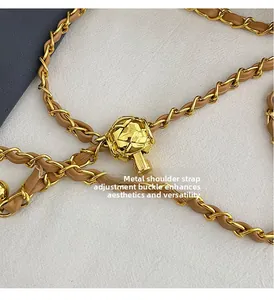 Détail de la boucle de réglage en métal doré sur la bandoulière en chaîne et cuir brun