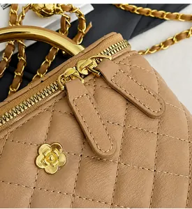 Détail du sac boîte en cuir matelassé beige avec logo camélia doré et fermeture éclair