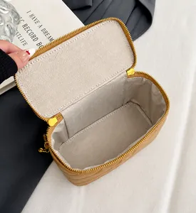 Gros plan d'un sac boîte en cuir matelassé beige avec grand intérieur et zip métallique