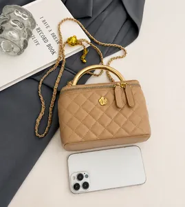 Mini sac boîte matelassé kaki avec poignée dorée à côté d'un téléphone pour la taille