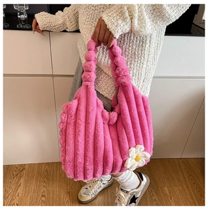 Detailed texture of pink plush tote bag with vertical stripes and daisy charm