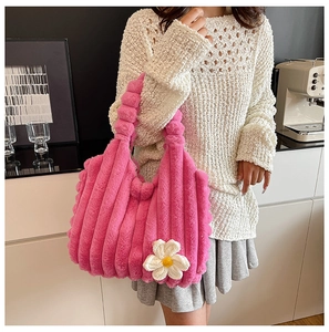 Detail of pink plush tote bag with ribbed texture and white knit daisy floral charm