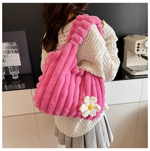 Detail of pink plush tote bag with quilted stripes and knitted daisy flower decor