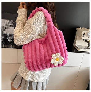Detail of pink plush tote bag showing soft fuzzy texture and woven flower ornament